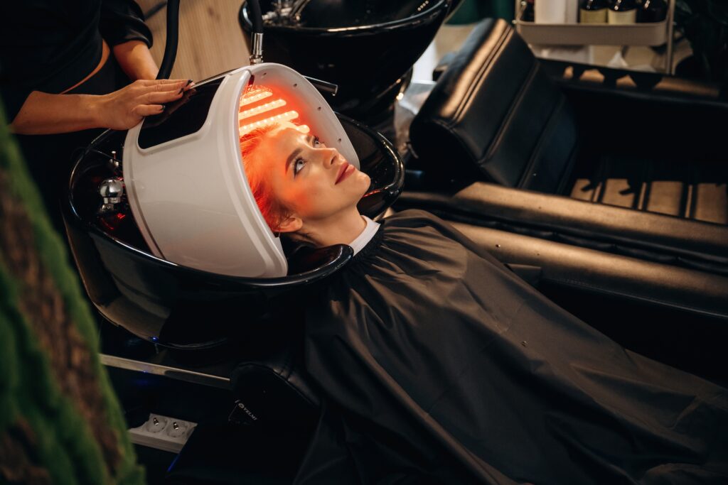 A woman using red light therapy for hair loss.