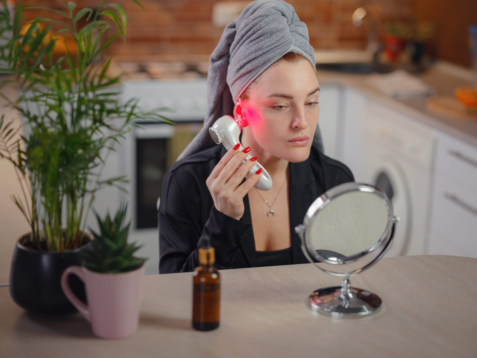 Woman using a handheld red light therapy device on her back at home